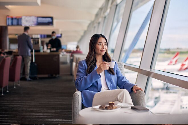 Woman having coffee in the Qantas Club lounge, Sydney Domestic Terminal