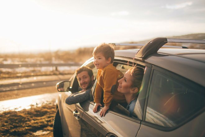 family in car at the beach