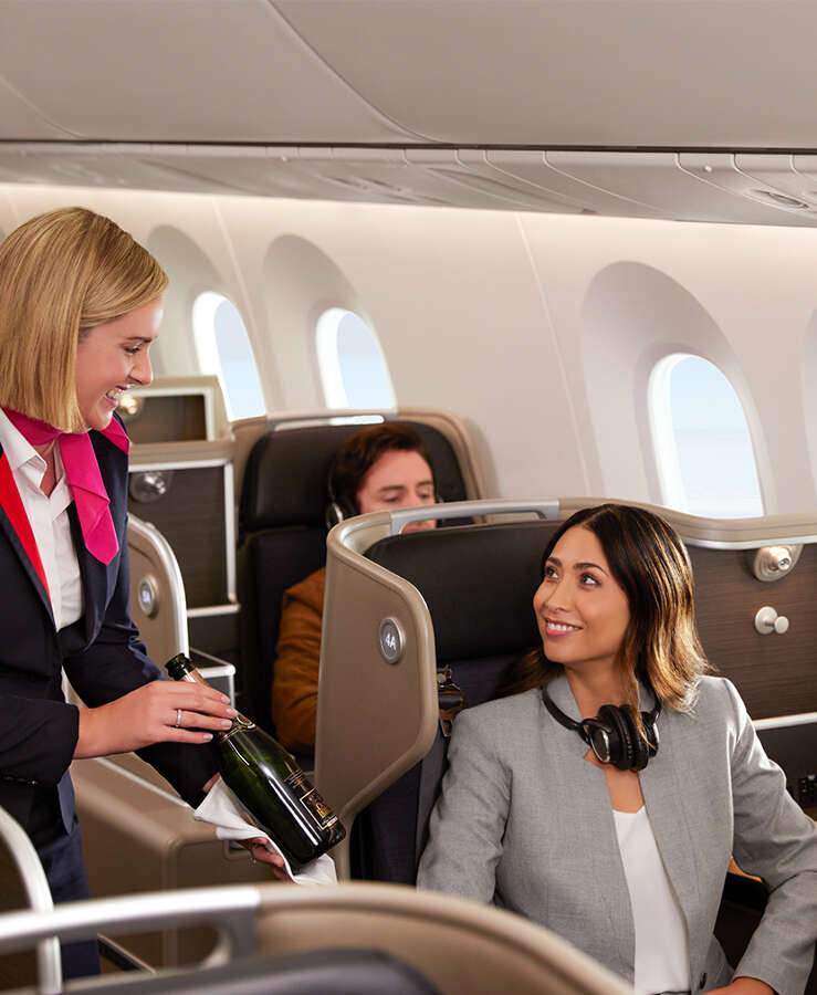 Woman being served in B787 Dreamliner business cabin