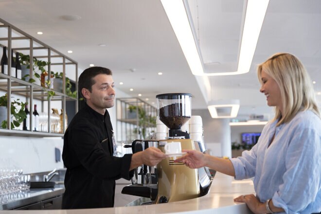 Customer being served coffee from the barista in the Brisbane International Business lounge