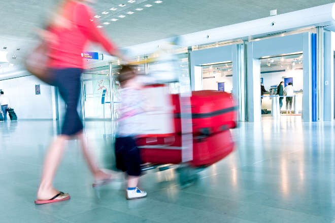 Lady with baggage trolley in terminal