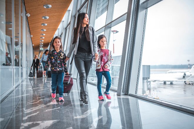 Mother walking with kids through the terminal