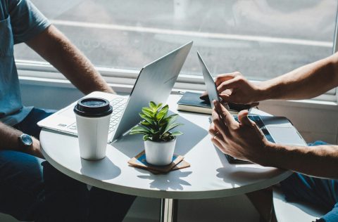 People working around laptops in a cafe