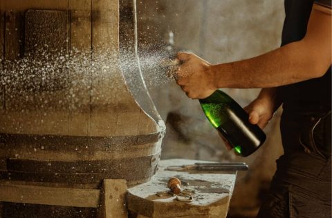 Popping a bottle of Champagne in a winery