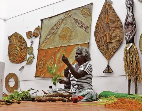 Maningrida indigenous woman demonstrating how to weave