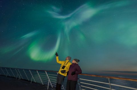 Guest Aboard the MS Trollfjord Marvel at the Northern LIghts Overhead